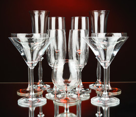 Cocktail and wine glasses, on dark red background