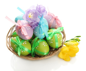 Bright easter eggs with bows in basket, isolated on white