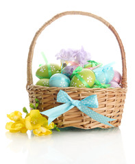 Bright easter eggs with bows in basket, isolated on white