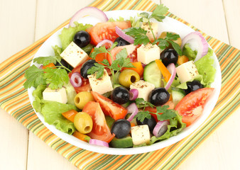 Fresh salad in plate on wooden table