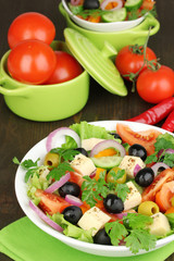 Greek salad in plate on wooden table