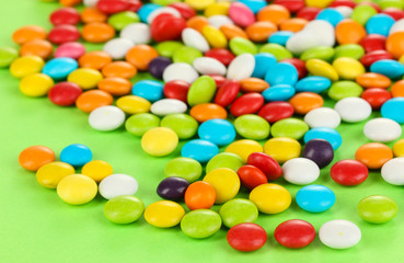 Fototapeta na wymiar Kolorowe cukierki na zielonym tle