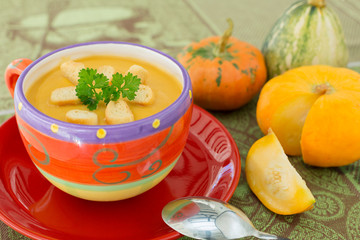 Pumpkin soup in colorful  bowl