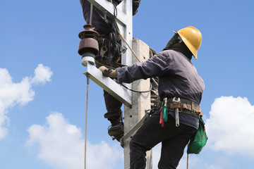 Electrician working on electric power pole