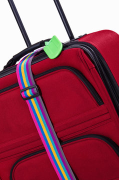 Bright Green Luggage Tag And Colorful Belt On Red Suitcase
