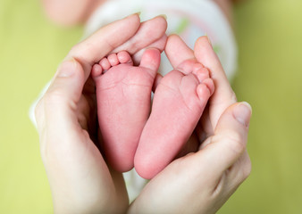 mother hands holding small baby's feet