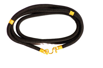 Fototapeta premium Black and gold rope on a white background.