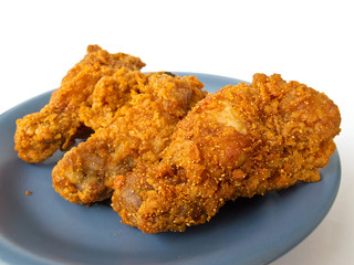 Spicy fried chicken on the blue dish with white background