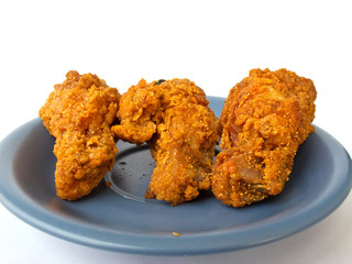 Spicy fried chicken on the blue dish with white background