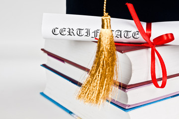 Graduation cap with book and diploma