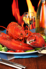 Red lobster on platter on wooden table on fire background