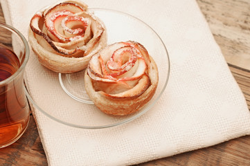 Obraz na płótnie Canvas Apple cakes with cup of tea like flower on wooden table