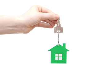 hand is handing a house key