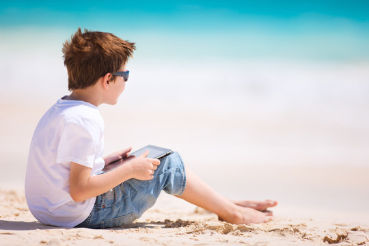 Boy With Tablet Device At Beach