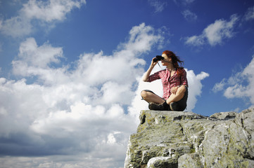 Woman sitting on a mountain with binocular