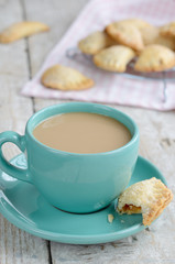 Cup of coffee with milk and apple pies on wooden background