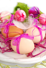 easter eggs with pink ribbon on the plate