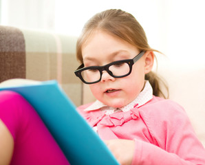 Little girl is reading a book