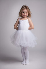 Little curly girl in a ballet dress