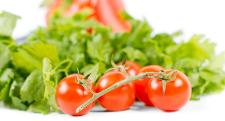 Fresh tomatoes on vine with green salad