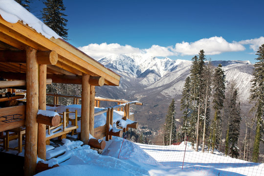 Wooden ski chalet in snow, mountain view
