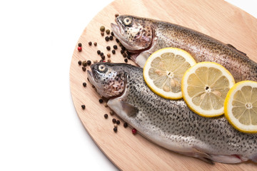 Trout on wooden plate isolated over white