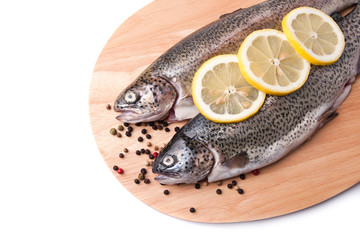 Trout on wooden plate isolated over white