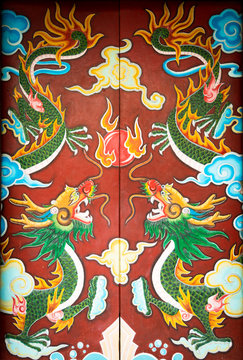 Colorful door with symmetrical dragon painting.