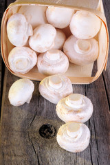 Fresh champignon mushroom on a wooden board