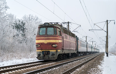 Fototapeta na wymiar Pociąg osobowy ciągnięty przez lokomotywę elektryczną