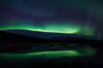 Northern lights above lagoon in Iceland