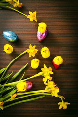 Easter Eggs and Chicks with Flowers on Wood Background