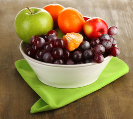 Naklejka na ściany i meble Bowl with fruits, on wooden table