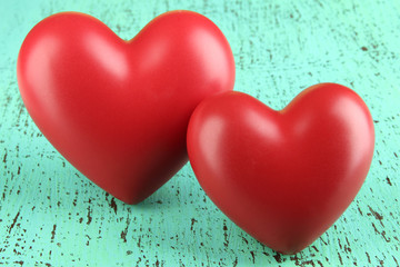 Fototapeta premium Decorative red hearts on color wooden background