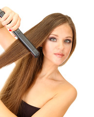 Woman doing hairstyle with hair straightener, isolated on white