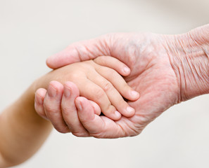 hands of young child and old senior