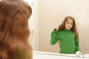 Girl looks at her reflection while getting ready