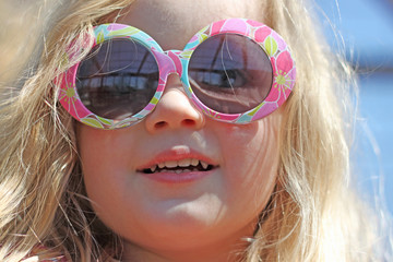 Cute little blonde girl wearing sunglasses