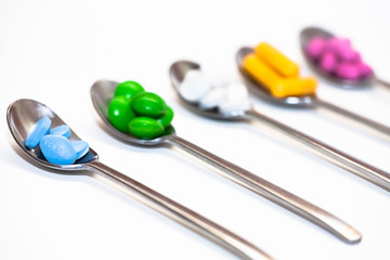 Bunte Tablettenmischung auf Löffeln