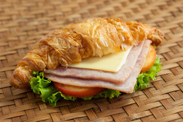 croissant ham cheese on brown bamboo weave