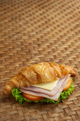 croissant ham cheese on brown bamboo weave