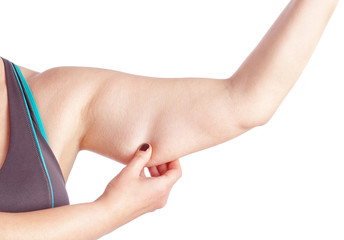 Middle-aged woman holding a hand with excess fat. On a white bac © Sergo