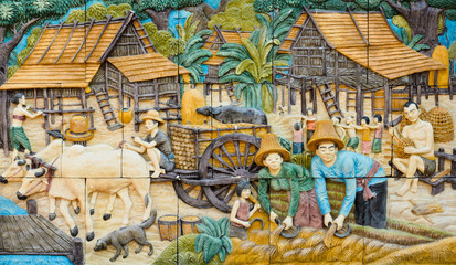Stone carving of traditional Thai rural culture on temple wall