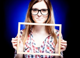 Smiling woman with nerd glasses holding frame