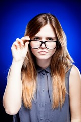 Fototapeta premium Young woman looking through the nerd glasses