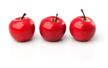 A set of three red plastic apples in a row