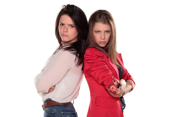 two scowling girl friends or sisters pose with arms crossed