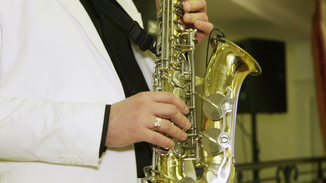 Man in a white suit, playing the saxophone