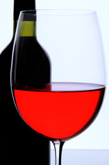 Red wine glass and bottle of wine isolated on white