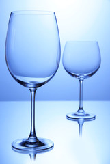Empty wine glasses arranged on blue background